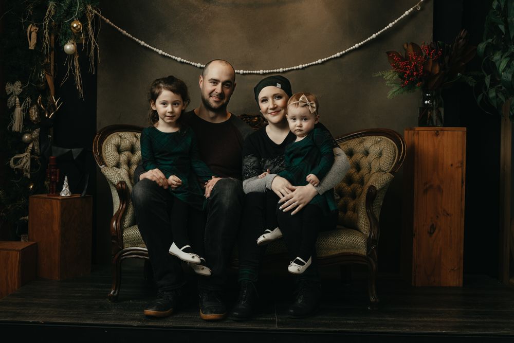 Moody indoor family portrait session with festive garland decorations.