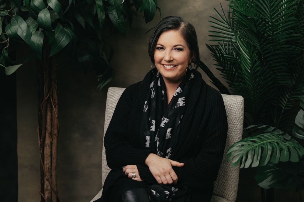Professional portrait with decorative plants and modern studio lighting.