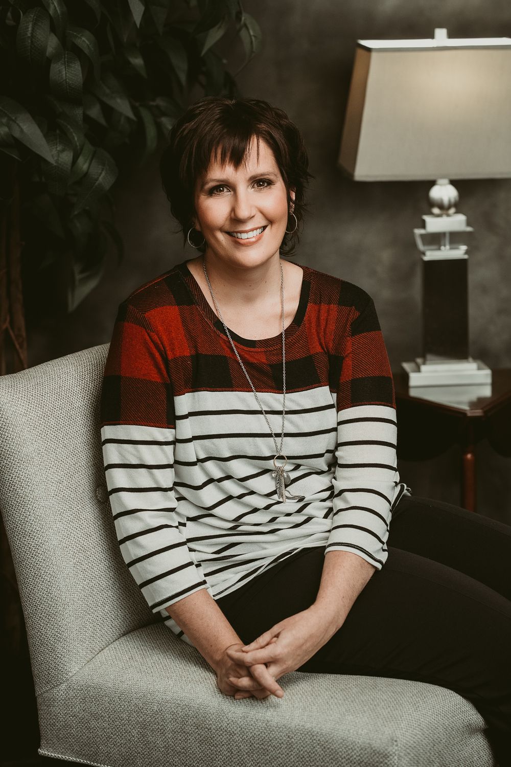 Casual portrait series showing someone in a red and white striped sweater on grey couch.
