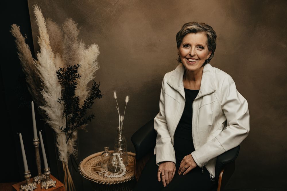 Professional studio photography setup with pampas grass decor and elegant white furniture.