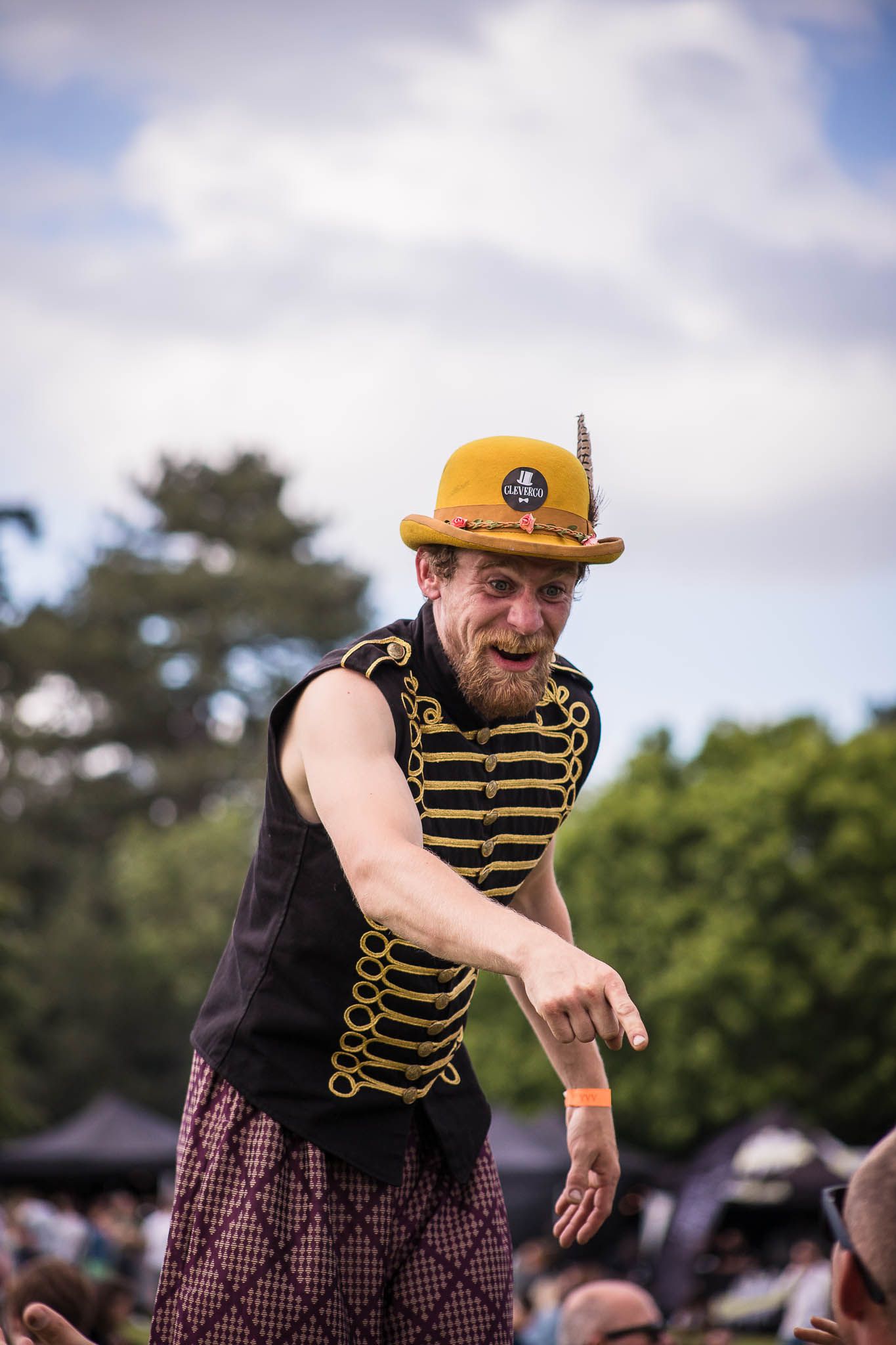 Festival imagery of man on stilts entertaining festival goers