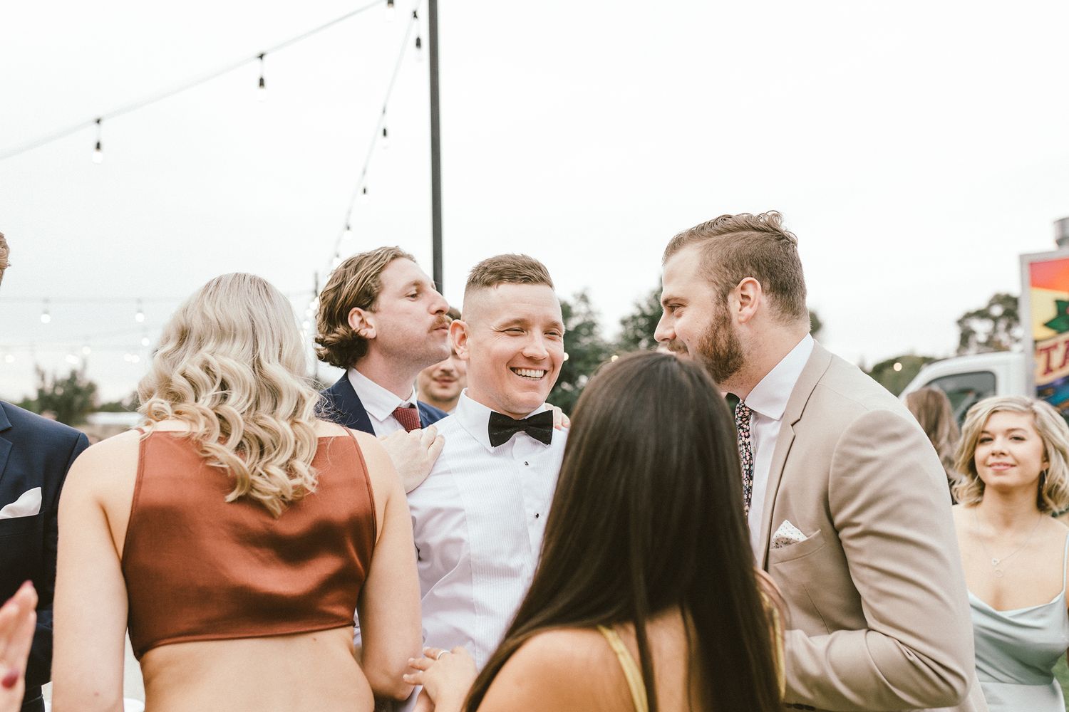 Candid moments of wedding guests laughing and celebrating outdoors.