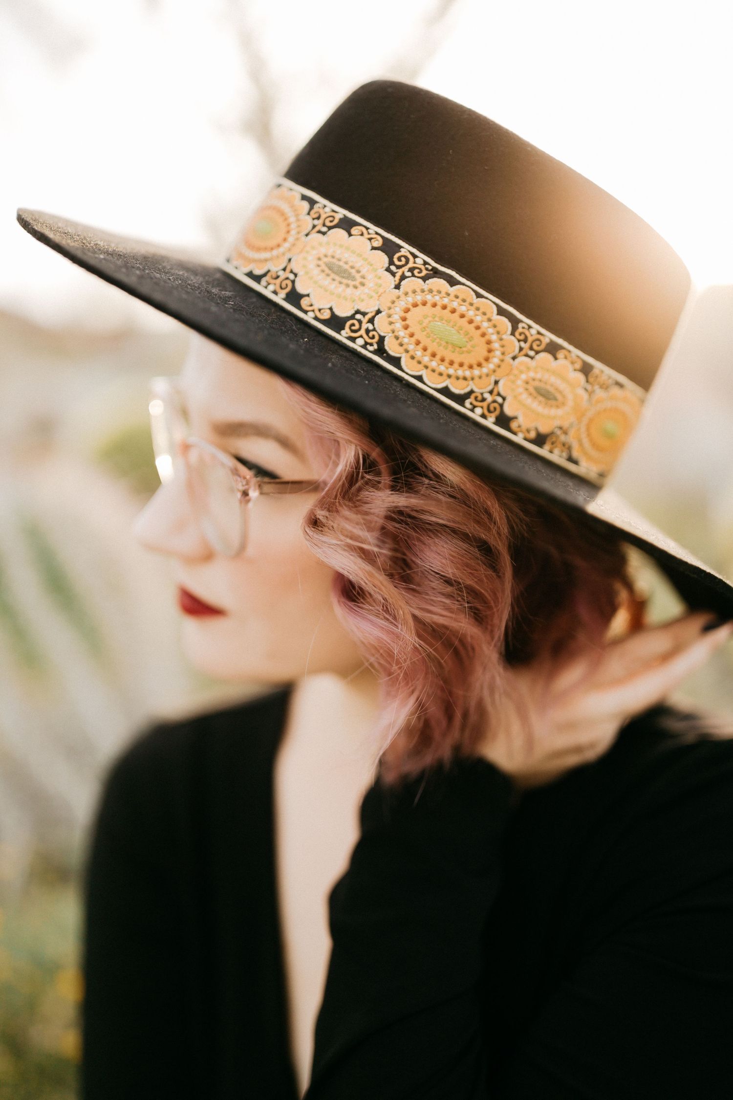 Close-up of decorative wide-brim hat with ornate band in warm sunset lighting.