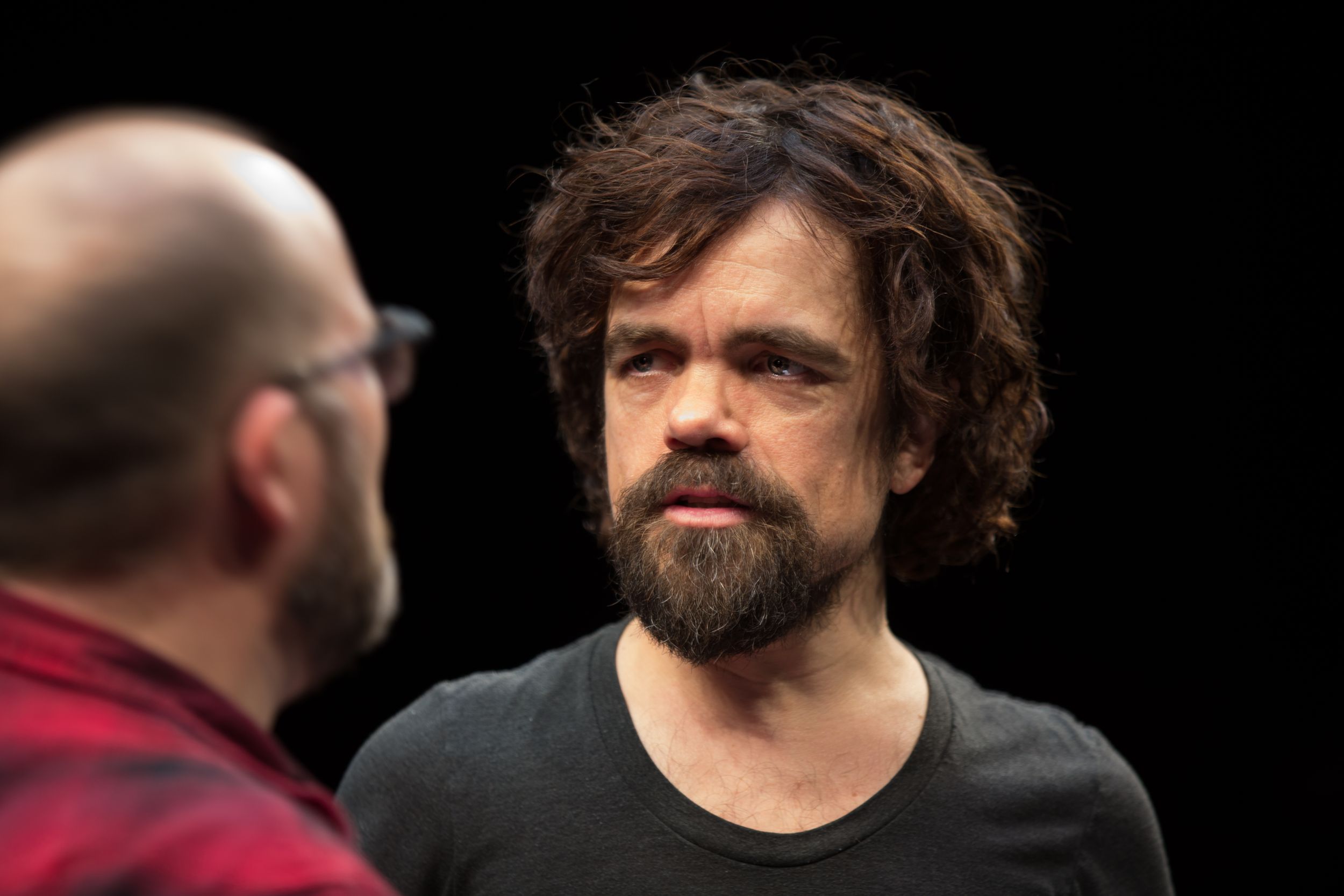 Performers engaged in conversation during what appears to be a theatrical production.