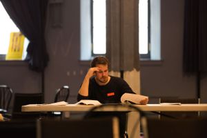 People working at tables in what appears to be a workshop or meeting room setting.