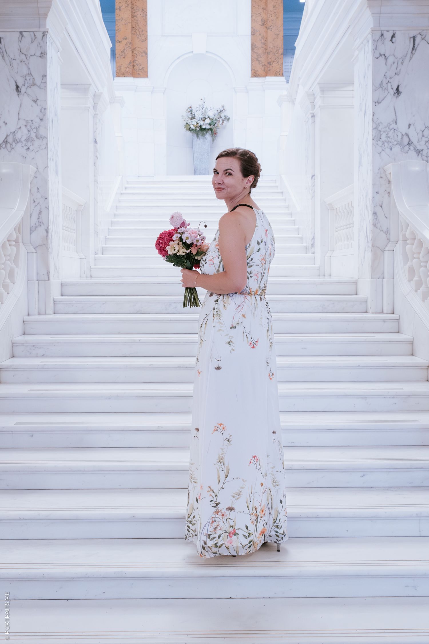 Bride standing on white stairs of Camden Town Hall