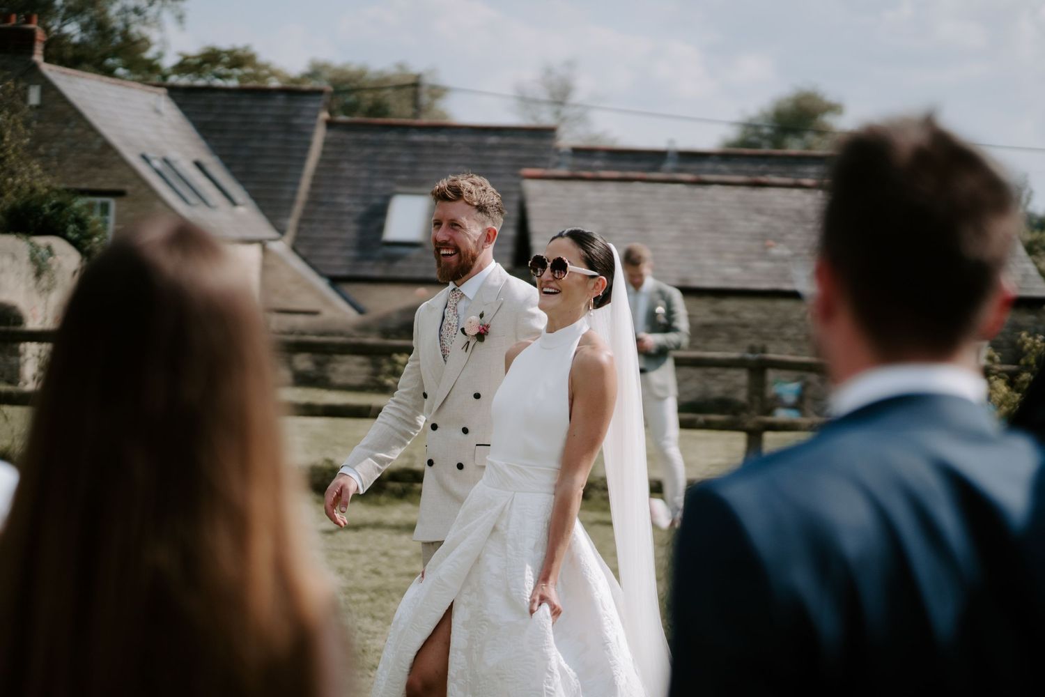 Bride and groom walking towards wedding guests outside marquee in islip, oxfordshire