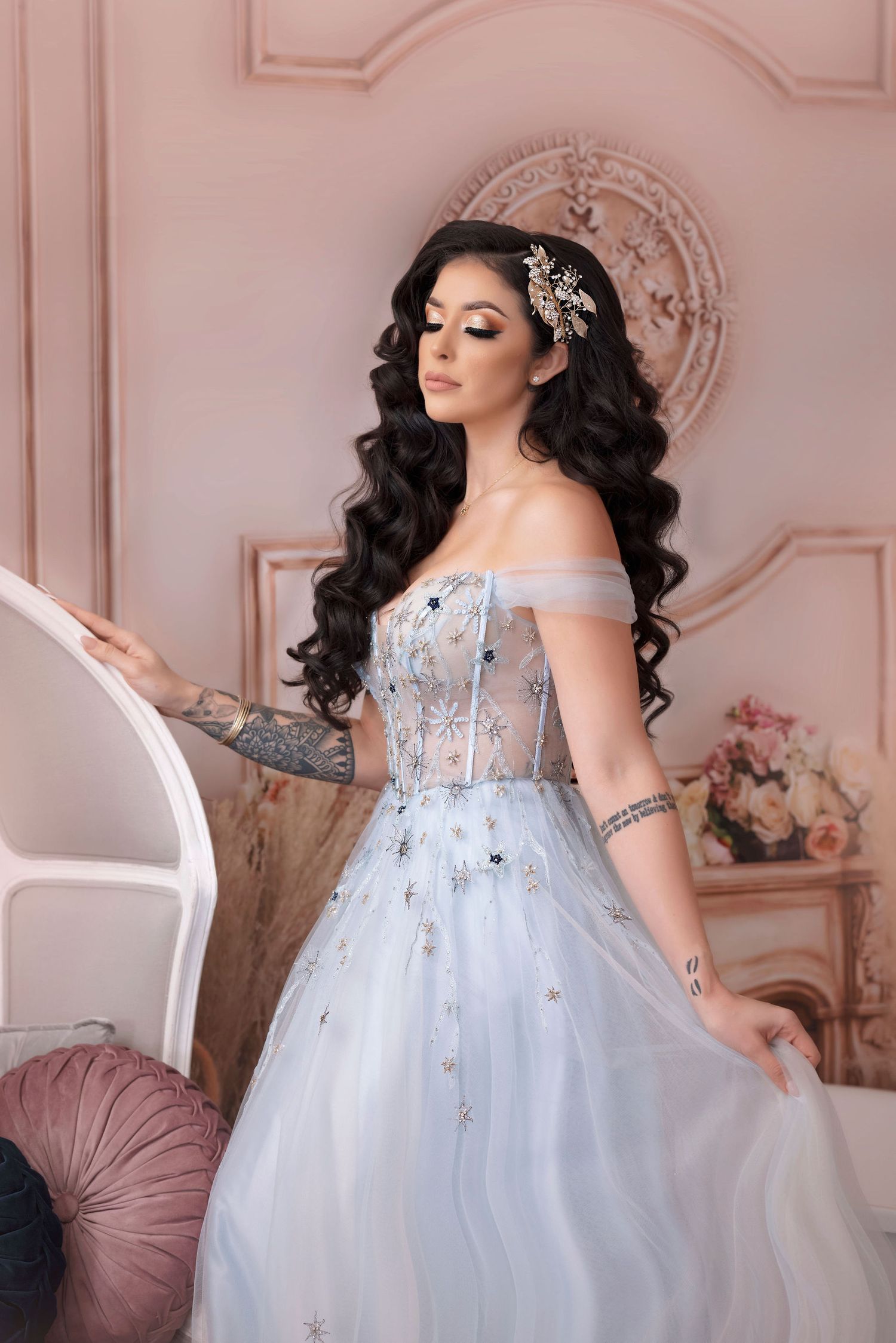 Ethereal pose in off-shoulder blue tulle gown with crystal embellishments.