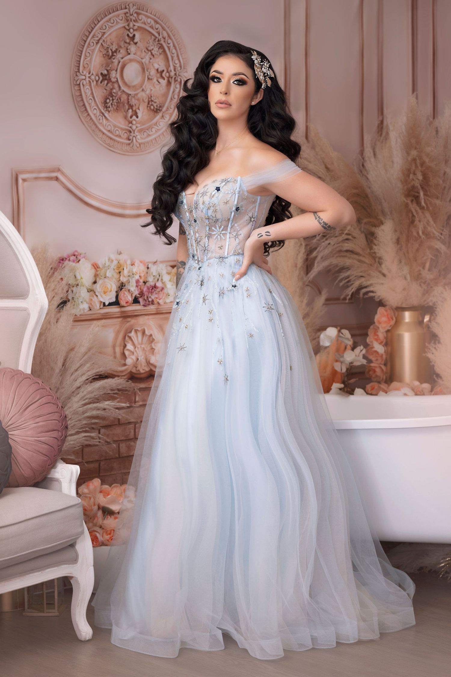 Romantic portrait in pale blue corset ballgown with crystal details against pink backdrop.