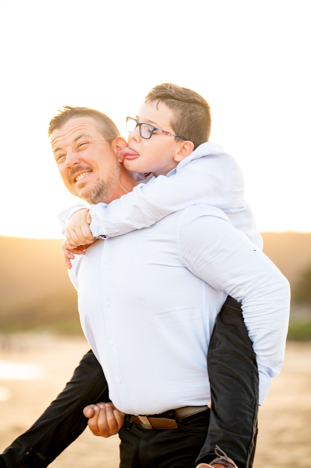 Son trying to lick his Dad while his dad pulls away pulling a funny face