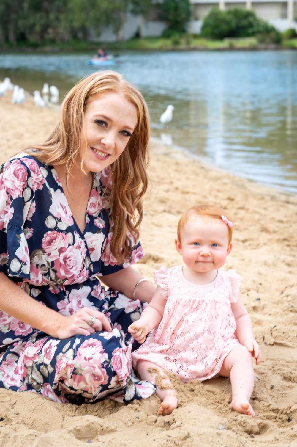 Mum and daughter playing in the sand by the lakes edge