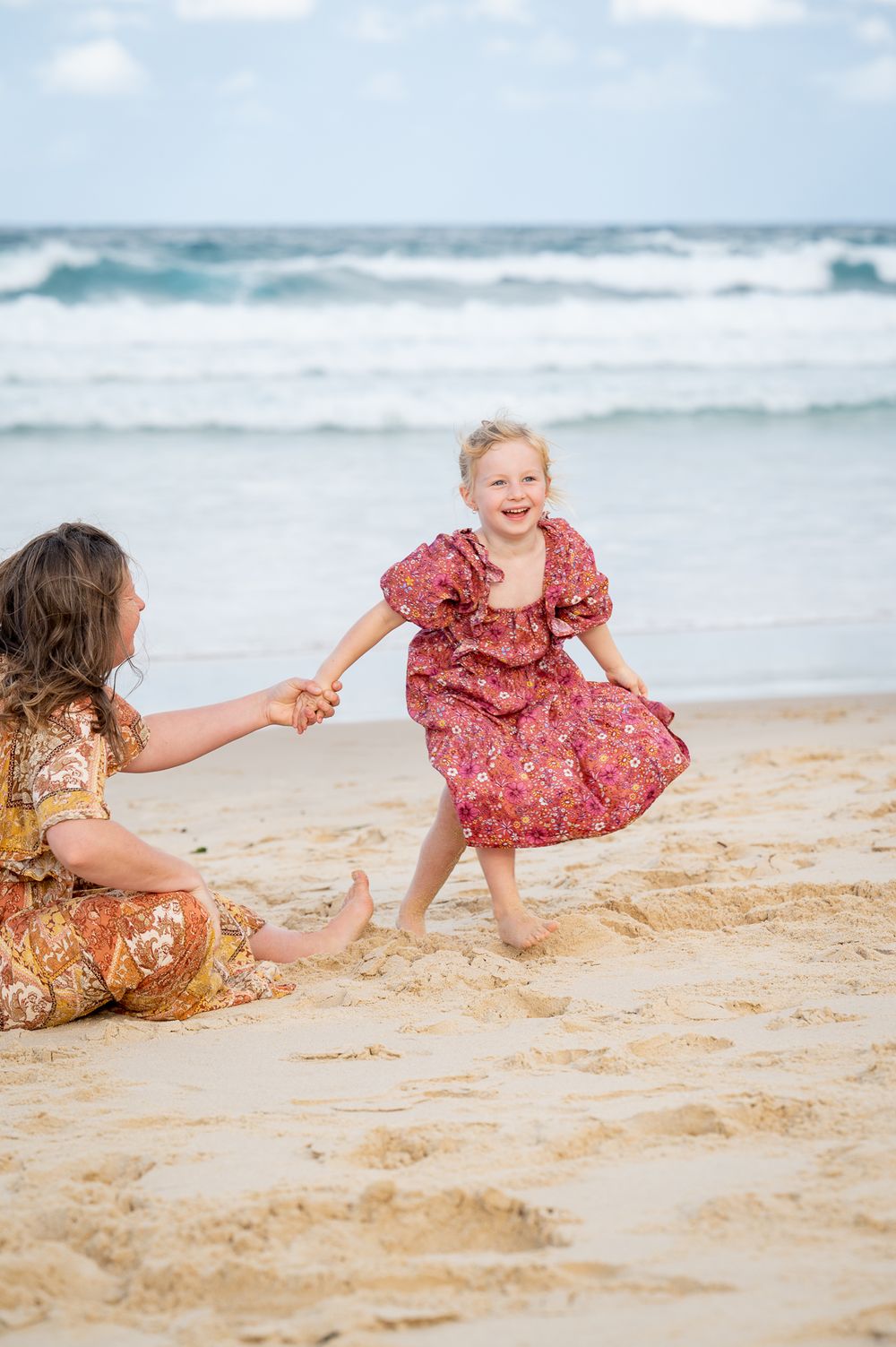 Mum and daughter playing by the oceans edge during a photoshoot