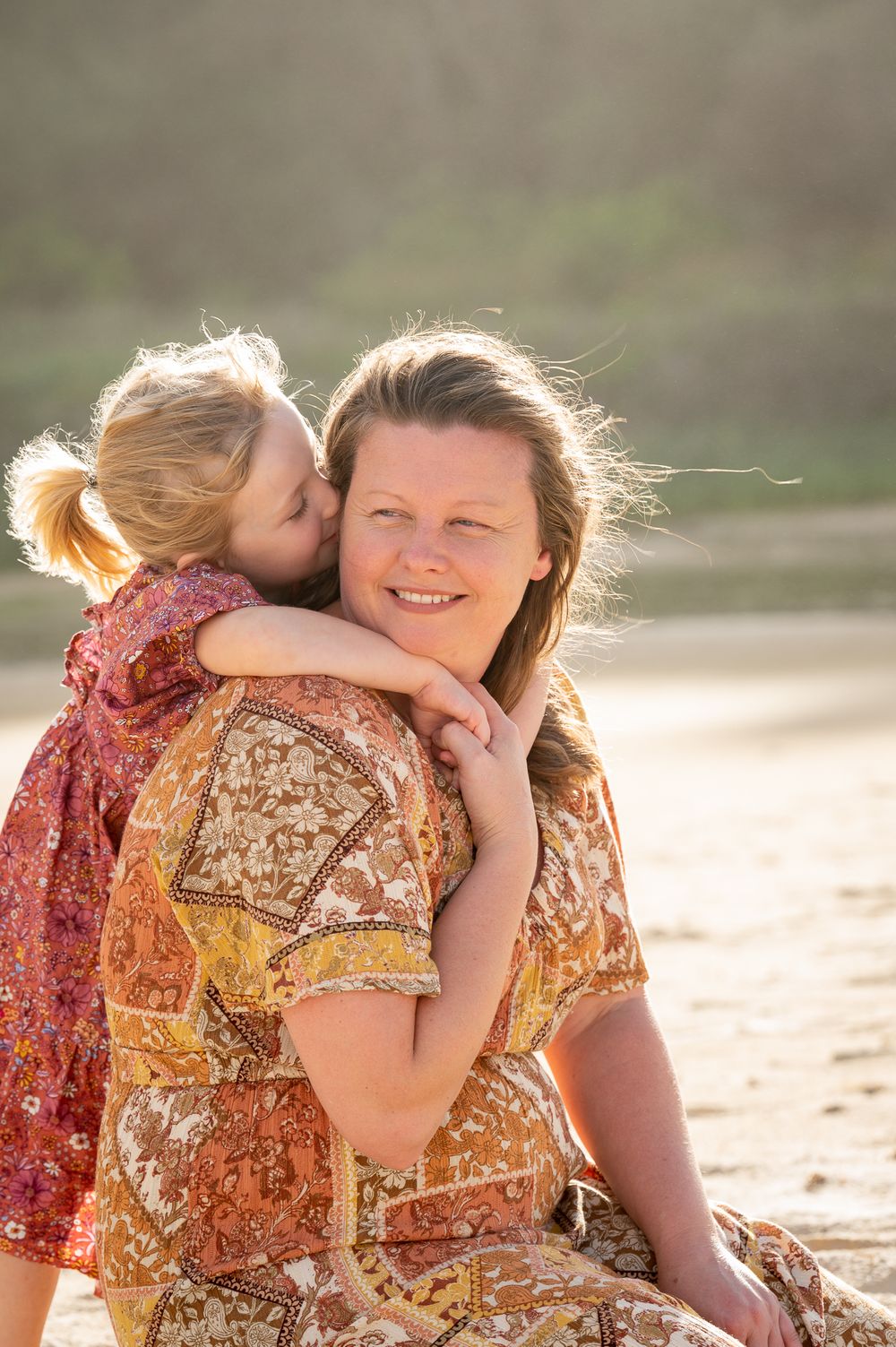Mum and daughter hugging at the beach