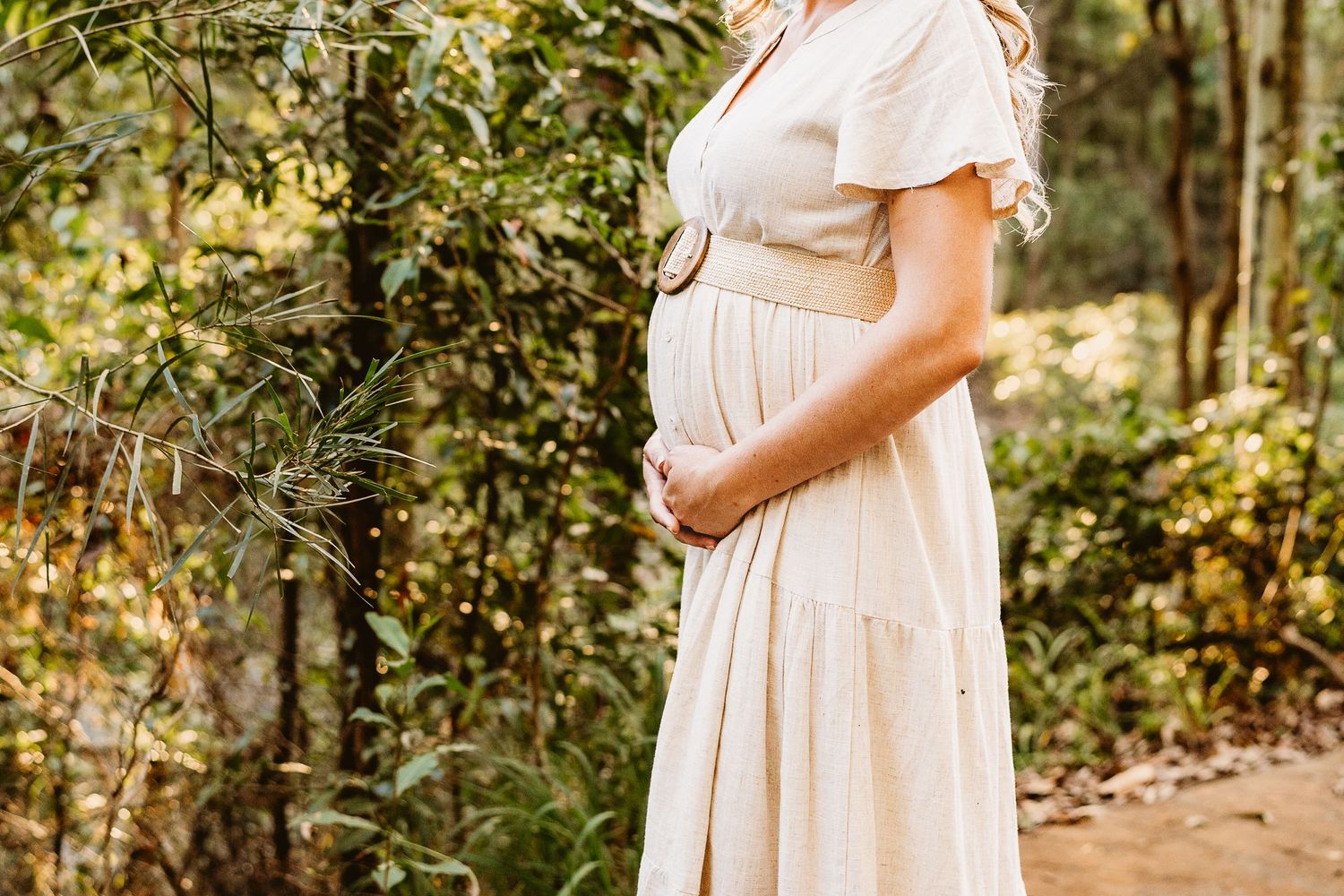 Expectant mum holding baby bump during maternity photos at Glenrock Reserve, Lake Macquarie