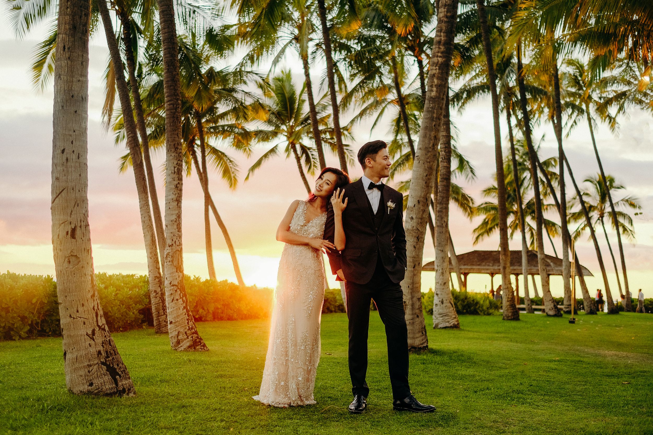 bride and groom captured by a wedding photographer during sunset at Lanikuhonua Venue, Ko Olina, Oahu.