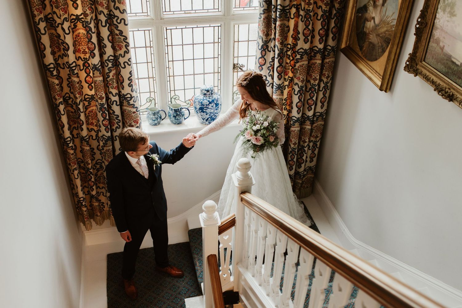 A couple shares a romantic moment on an elegant staircase during their wedding day.