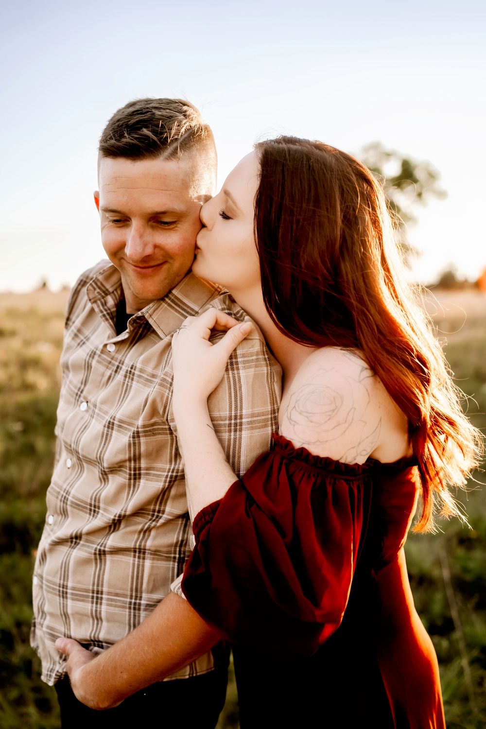 An intimate couples portrait captured during golden hour in a natural outdoor setting.