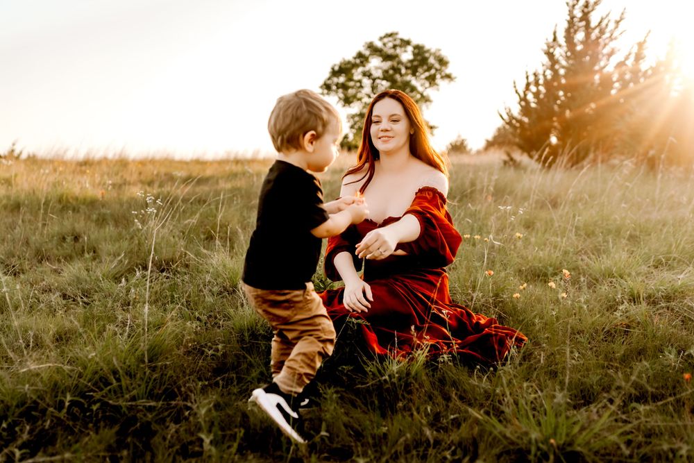 A heartwarming family scene photographed in a rustic field at sunset.