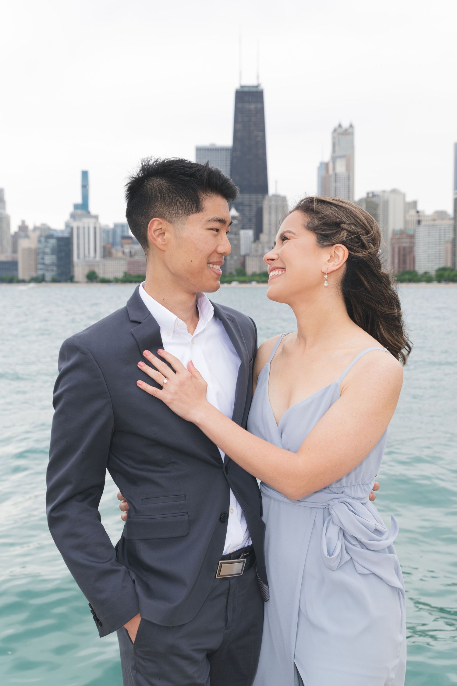 A couple shares an intimate moment against the Chicago skyline backdrop over Lake Michigan.