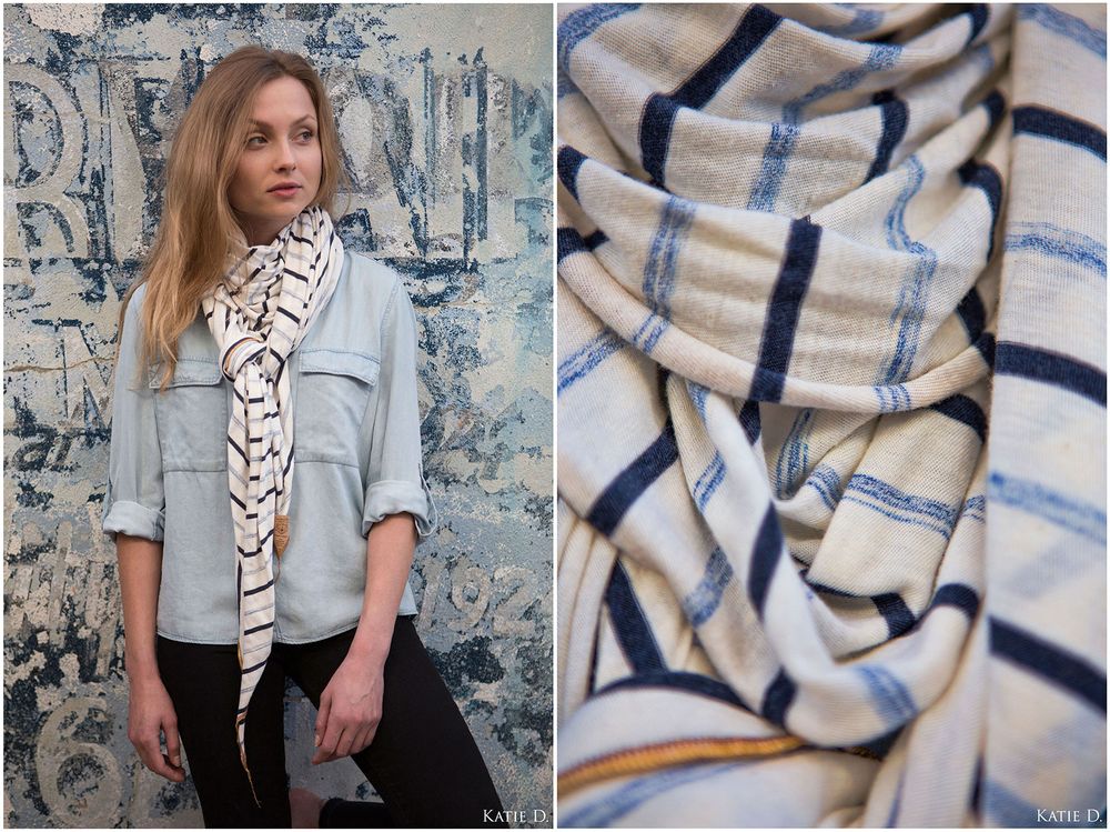 Woman in light blue jacket wearing a cream navy plaid knit scarf.