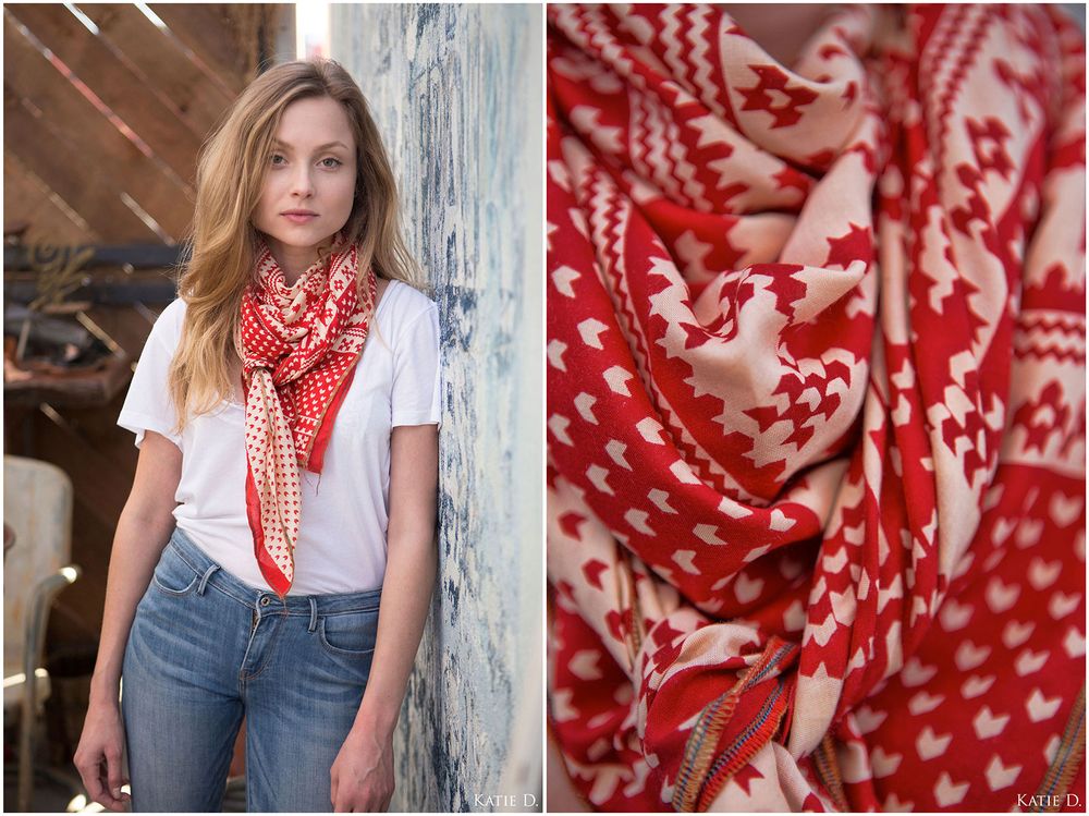 Woman in white tee wearing a red and white houndstooth patterned scarf with fabric detail.