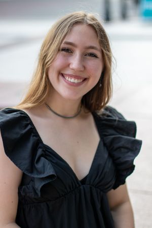 Portrait in black ruffled dress with natural outdoor lighting.