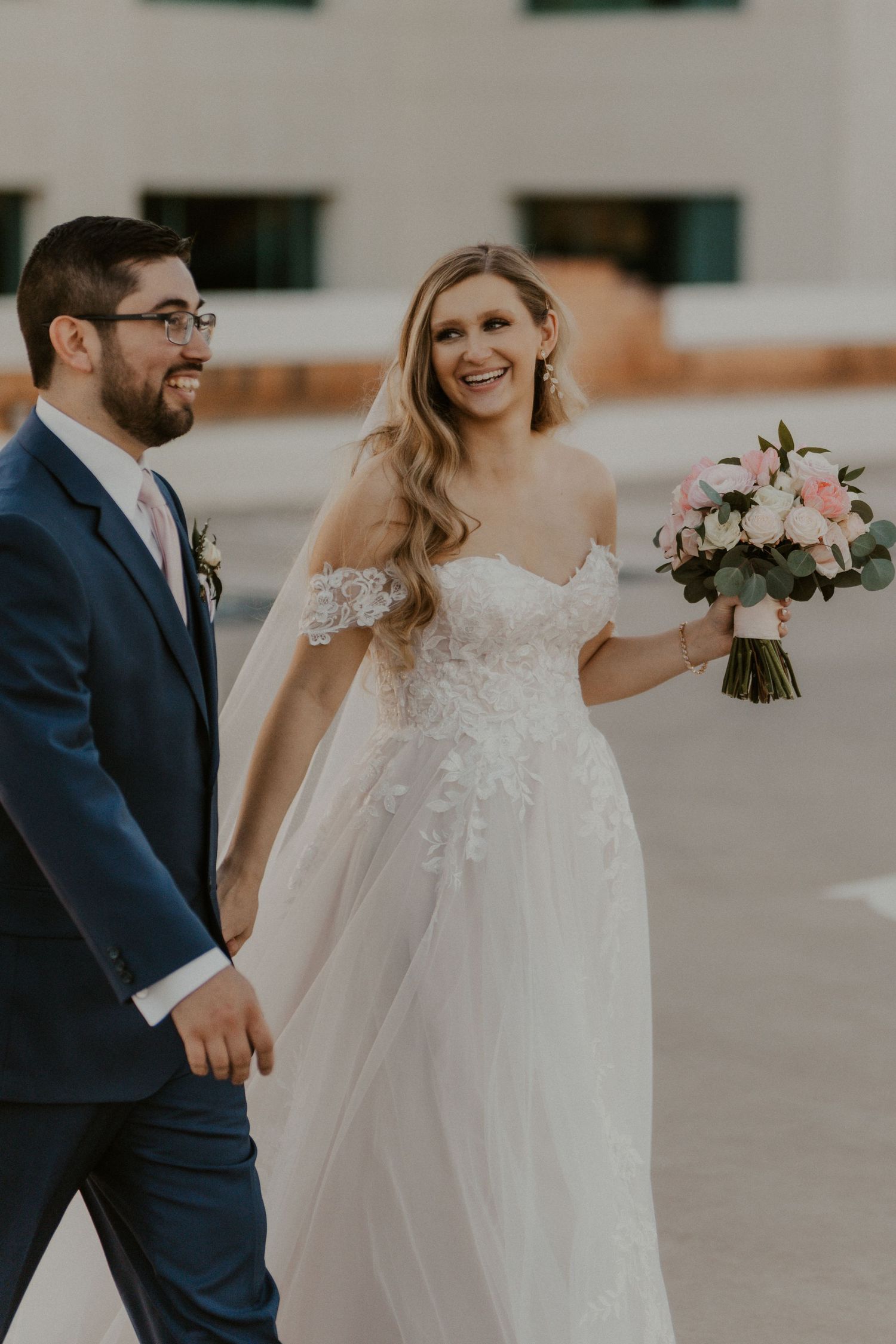 bride and groom walking on the top of a parking garadge in downtown Phoenix