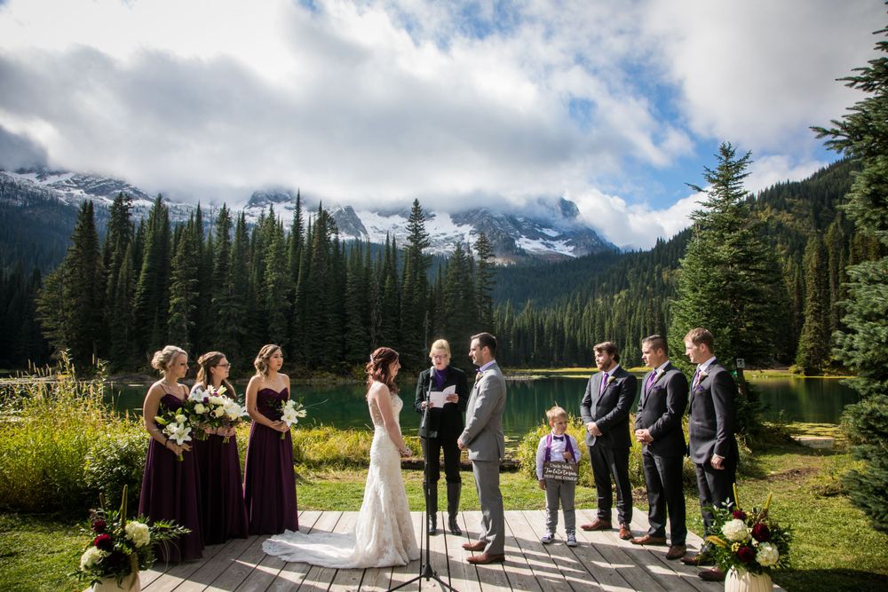 Wedding ceremony takes place on mountain terrace with snow-capped peaks in background.