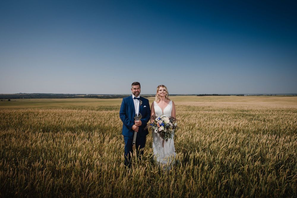 Golden wheat field stretches to horizon creating dramatic wedding portrait backdrop.