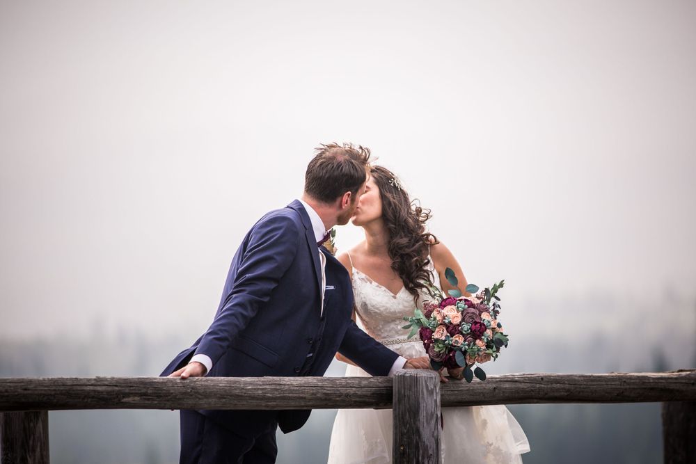 Romantic wedding portraits taken against a misty mountain landscape.