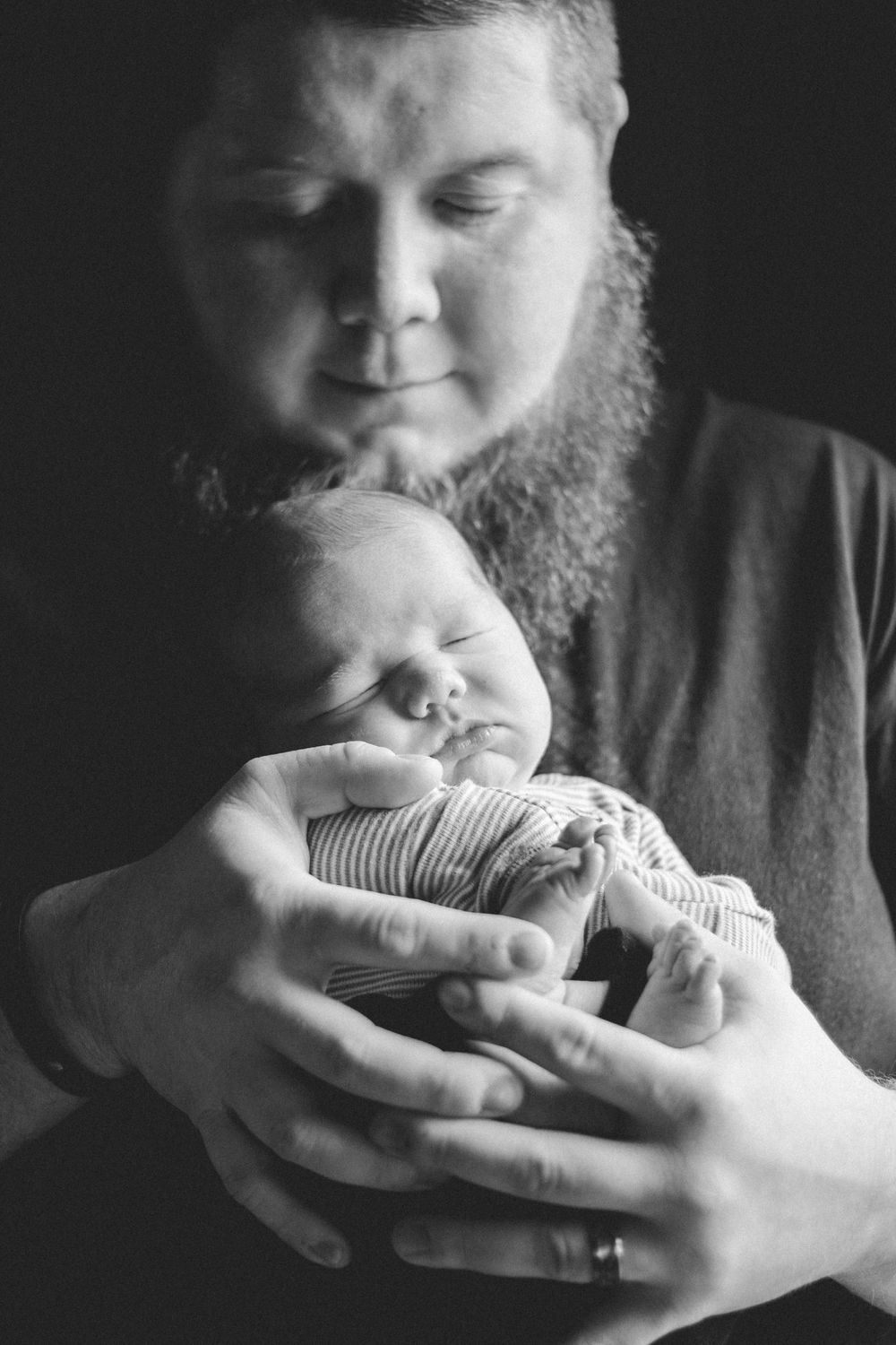 Black and white series showing tender moments between parent and newborn baby.
