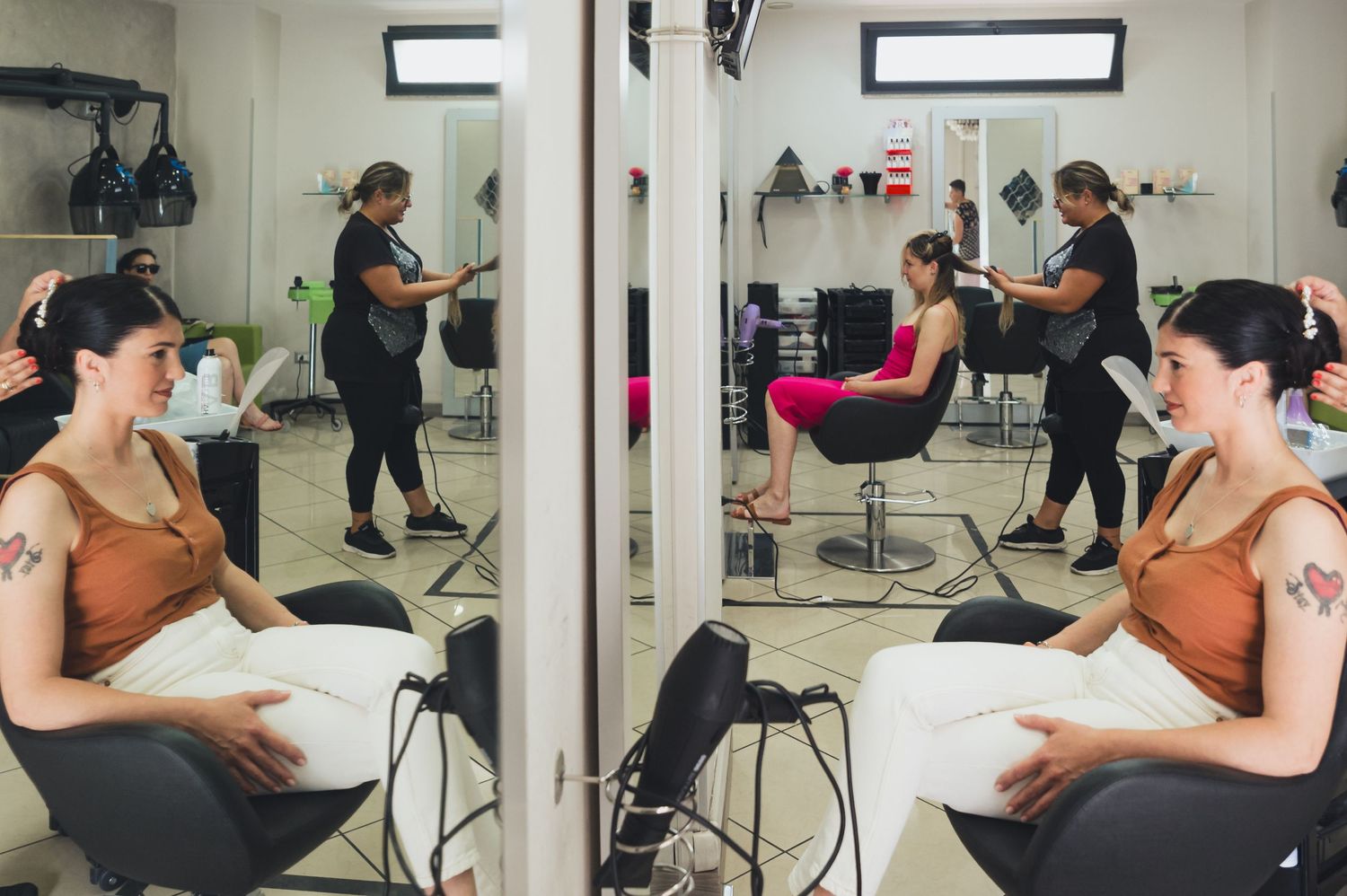 A mirrored reflection of a hair styling session in a modern salon space.