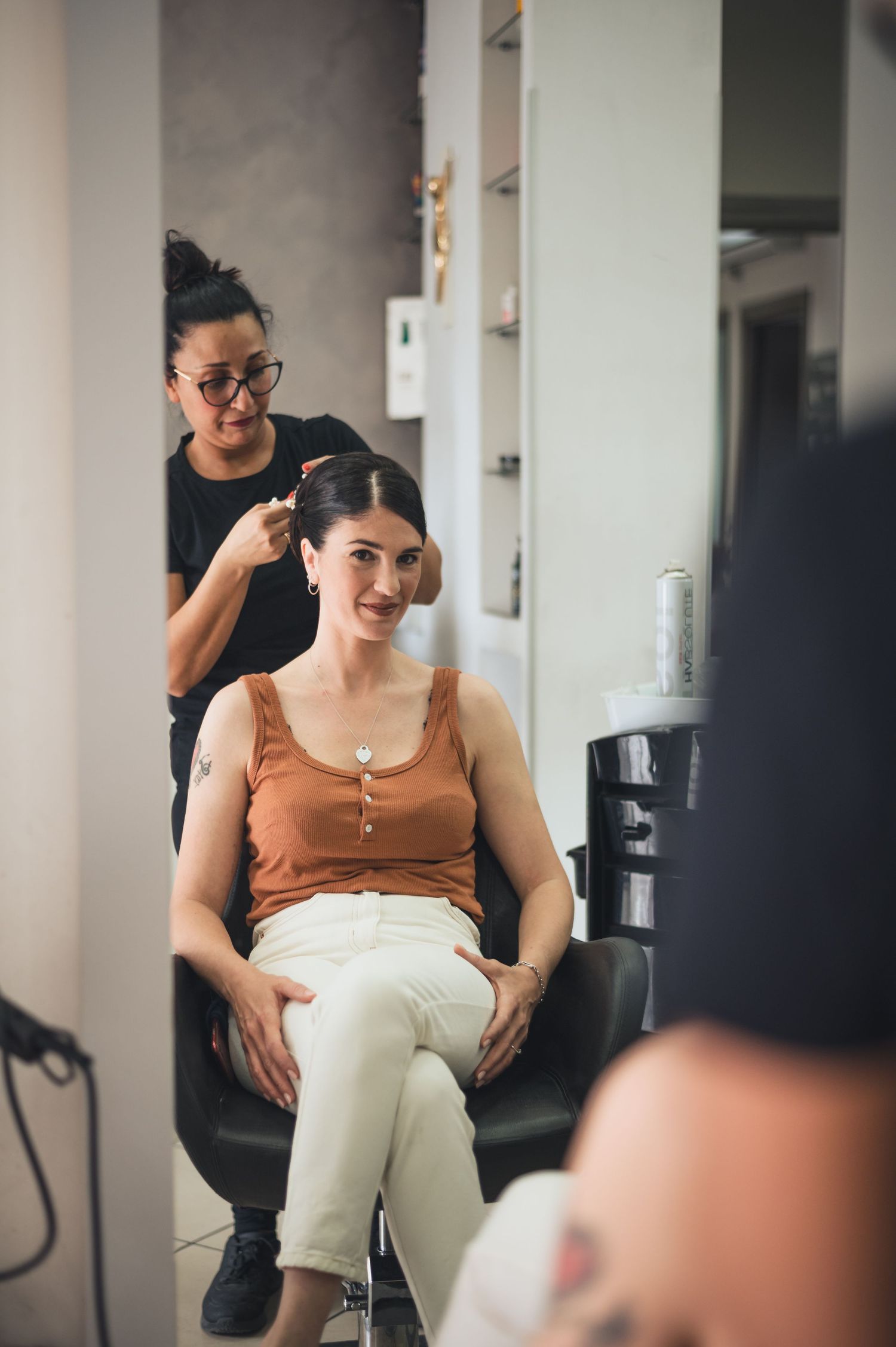 A styling session in progress at a modern salon with mirror reflections.