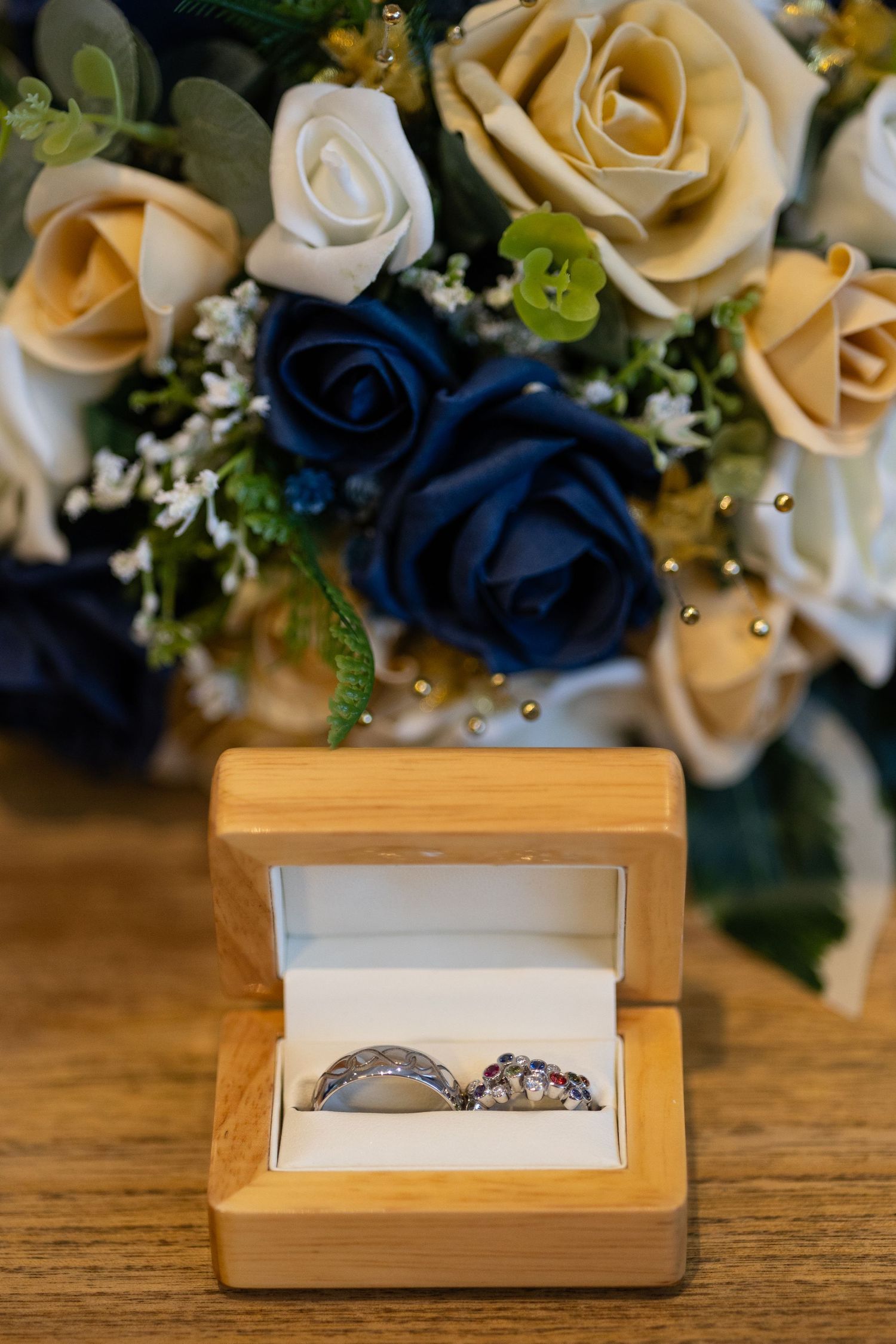 Wedding rings with the brides flowers in the background.