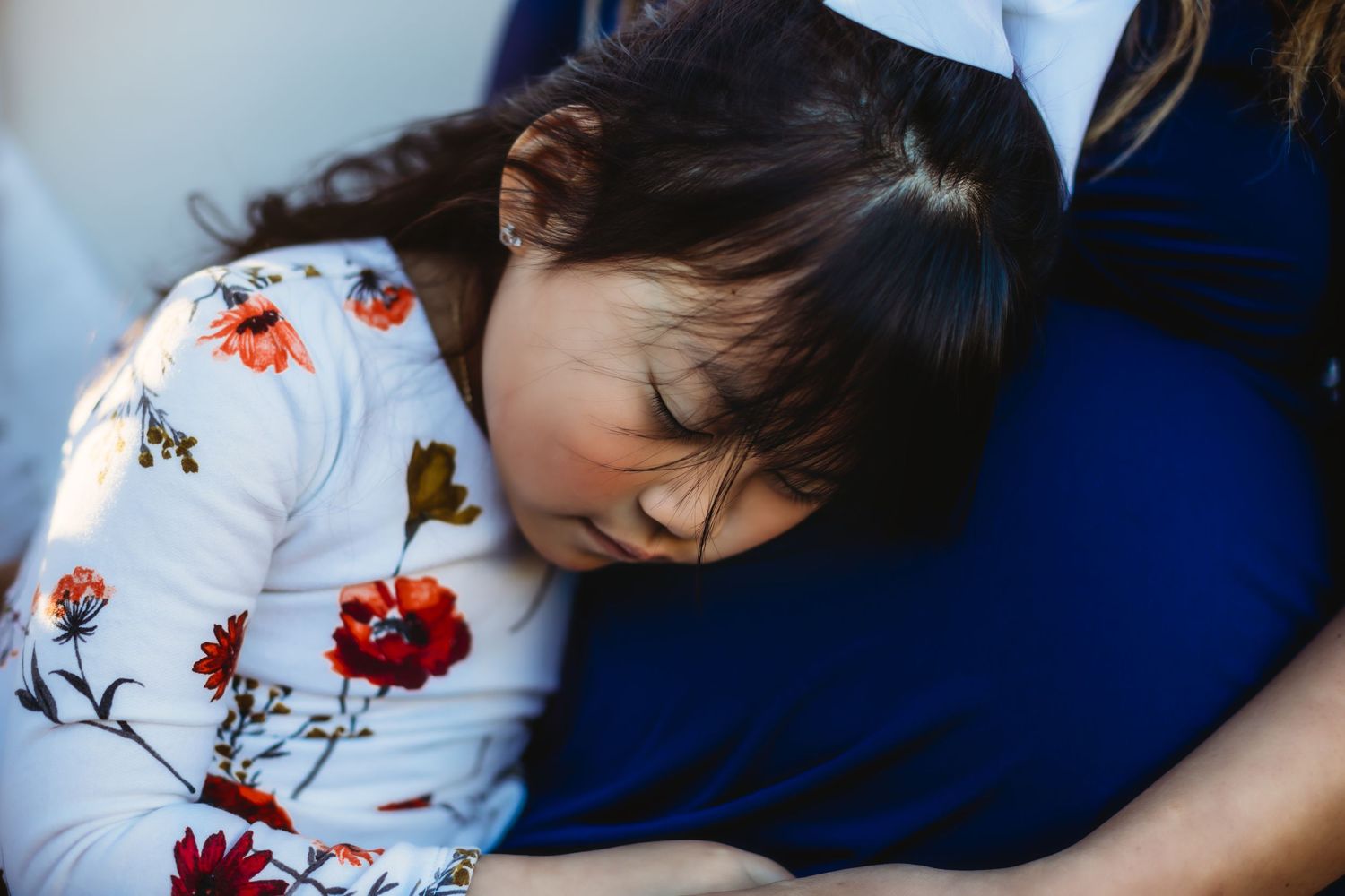 Peaceful sleeping moment in blue and floral patterns captured in close-up detail.