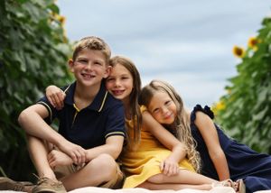 Family members pose playfully together in a sunflower field.