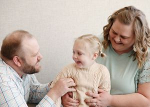 Family portrait series showing candid interactions and laughter in studio setting.