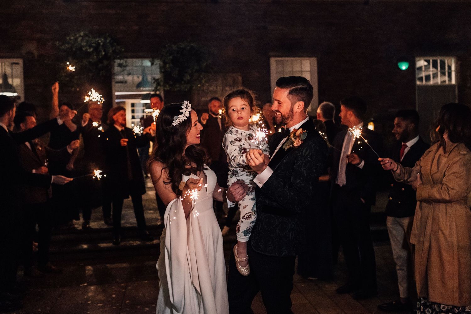 bride and groom holding sparklers outside