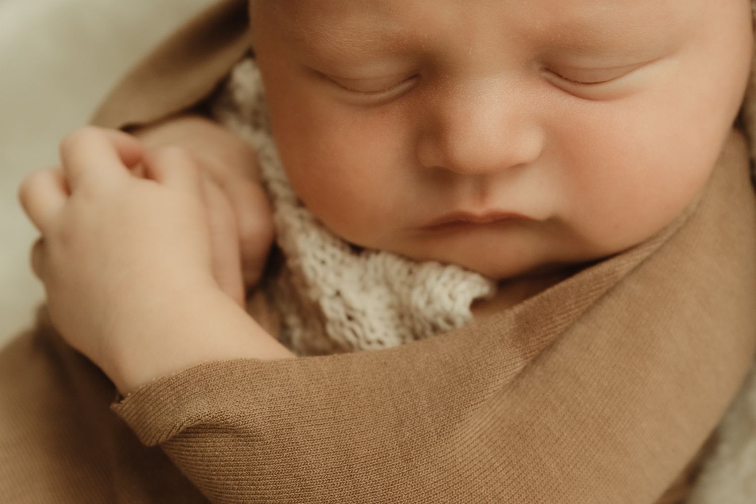 Newborn baby swaddled closeup. Image by dmcgphoto.