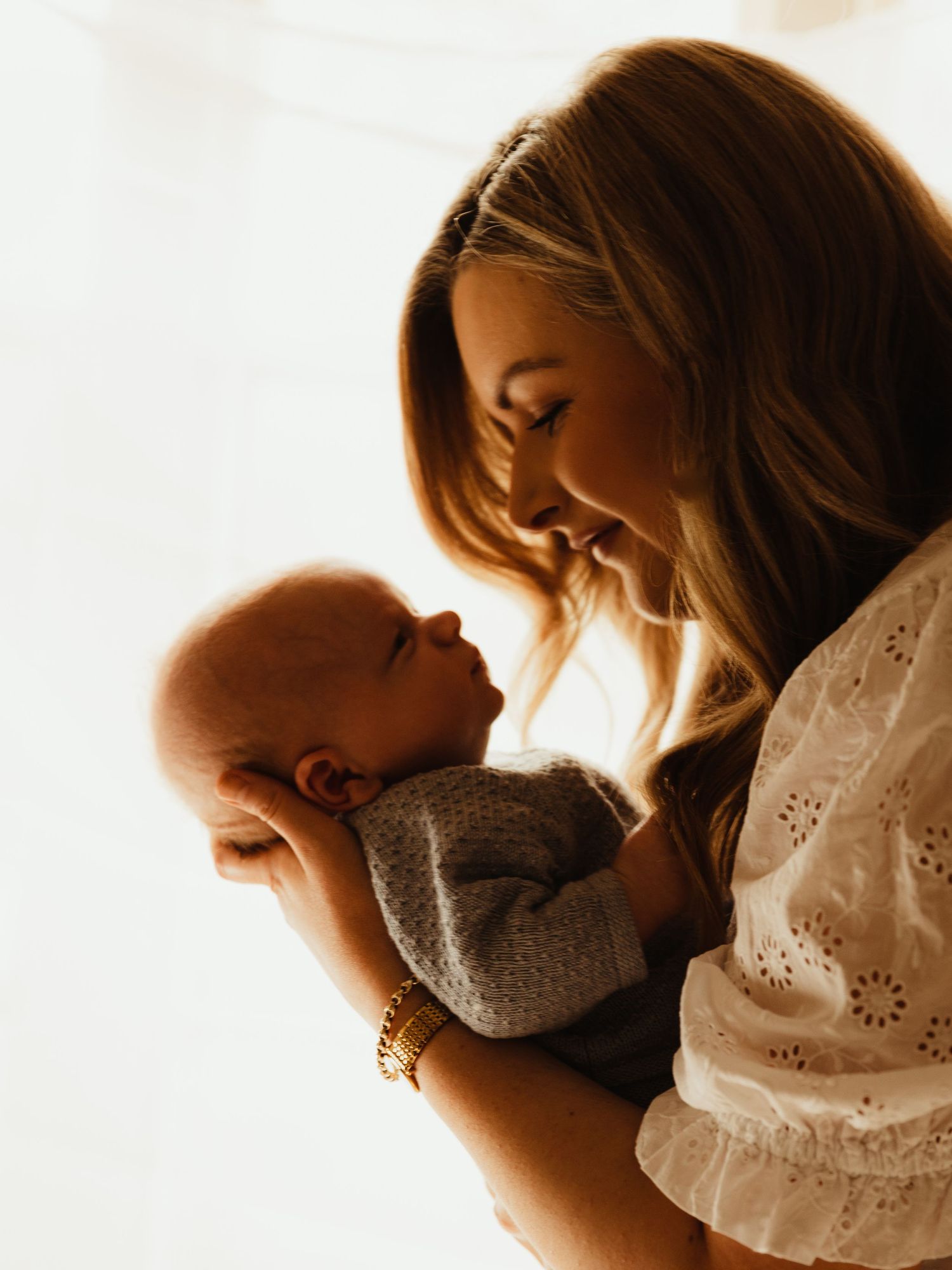 Newborn held by mother. Image by dmcgphoto