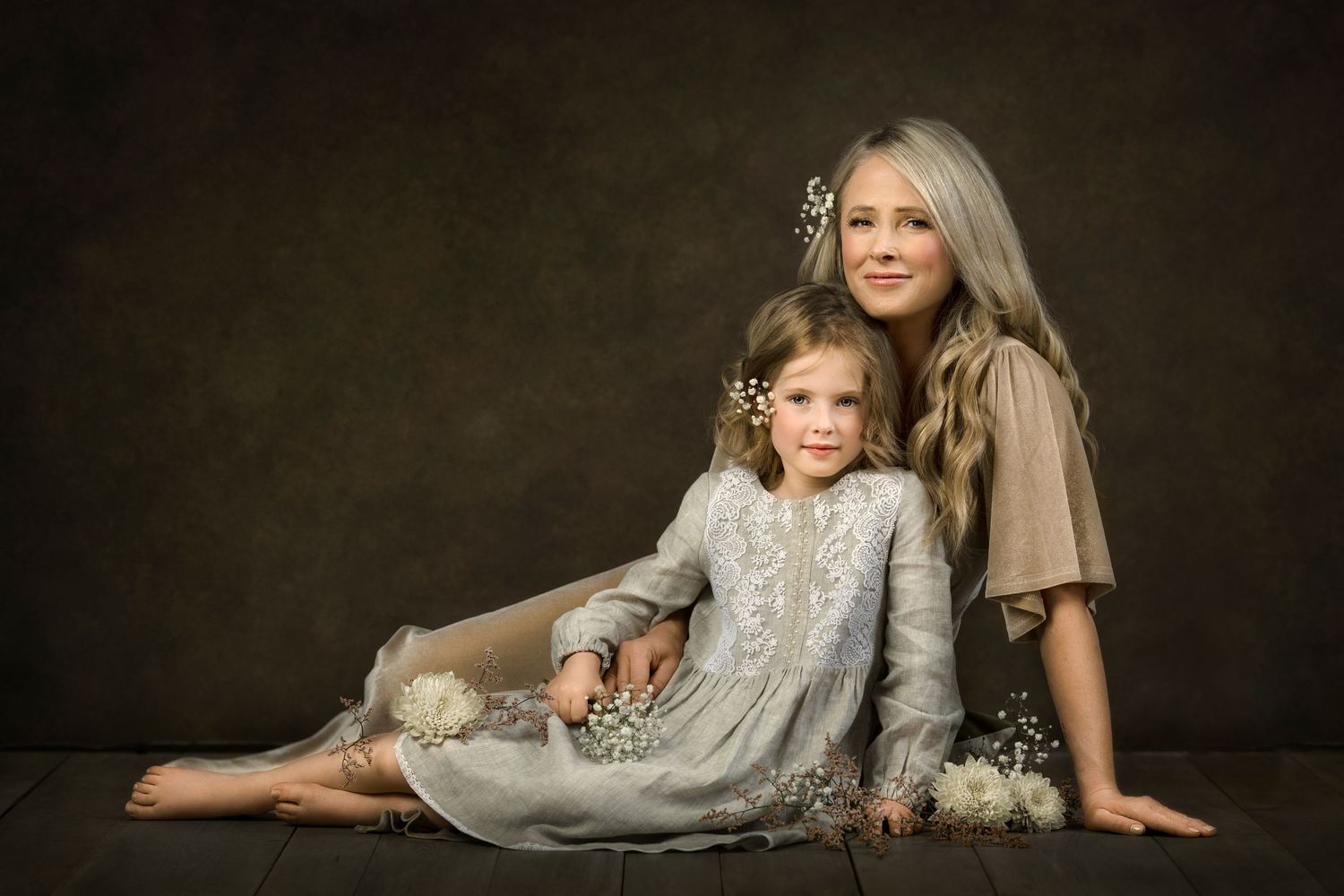 Studio mother and child portrait featuring soft earthy tones and elegant flowing dresses in a timeless composition.