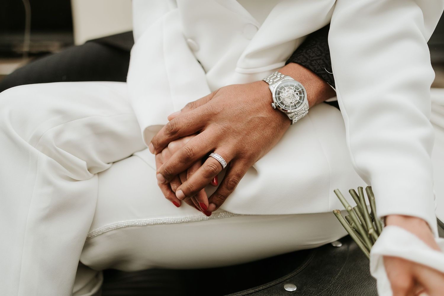 East Midlands wedding photographer - Intertwined hands, bride in a white suit and husband showing his wedding ring