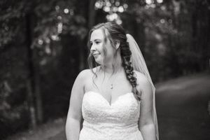 A black and white bridal portrait showcases intricate lace details of the wedding gown.