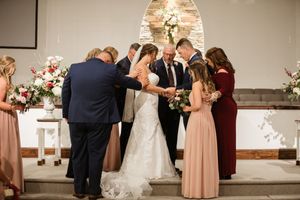 Wedding party gathered in an elegant indoor venue with warm lighting and romantic atmosphere.