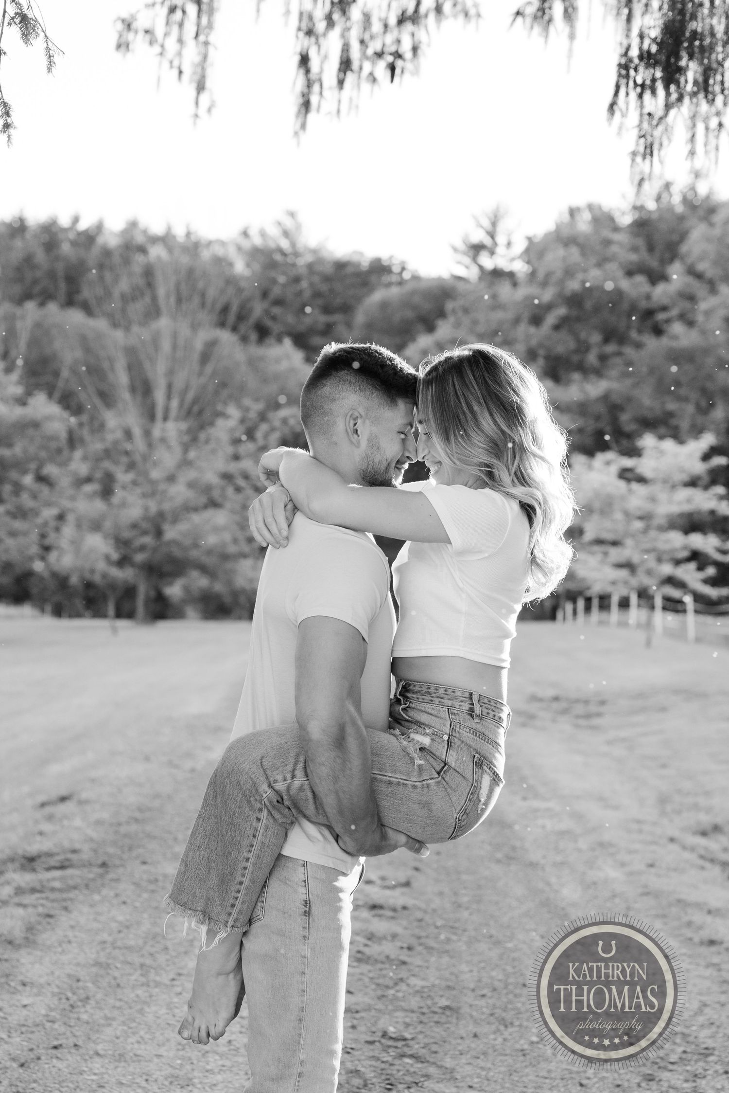 Black and white portrait of couple embracing in outdoor setting.