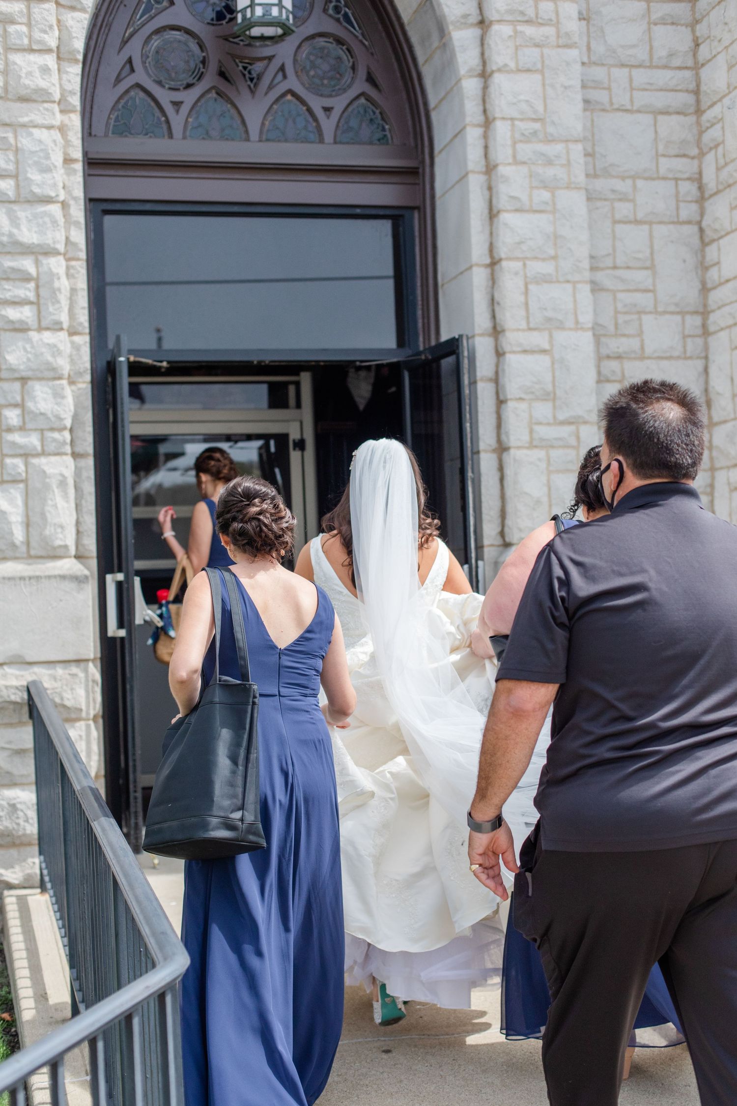Wedding photographers capturing moments outside historic stone church entrance.