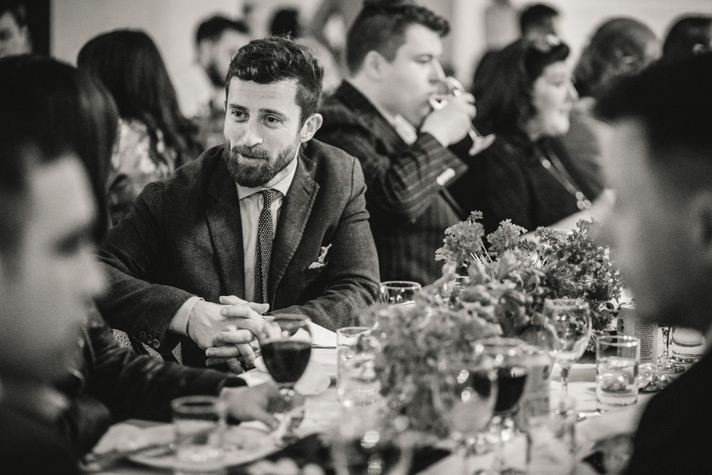 Guest enjoys dinner conversation at an elegant table setting with floral centerpieces.