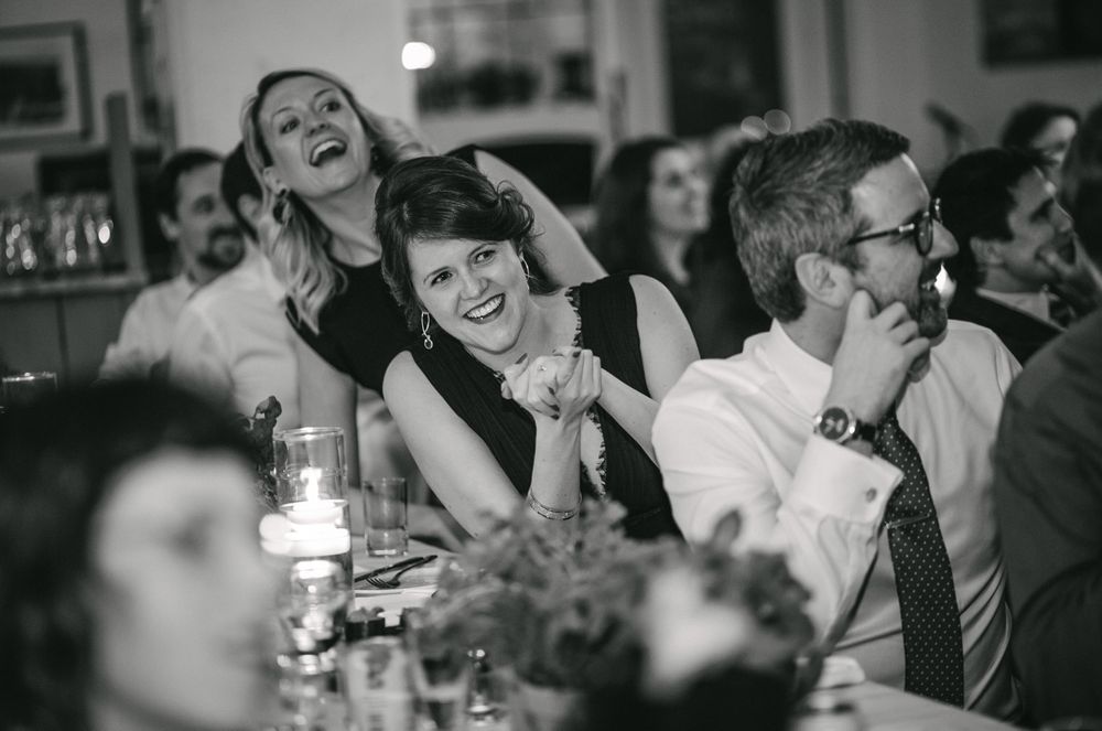 Guests enjoying lighthearted moments during formal dinner celebration.