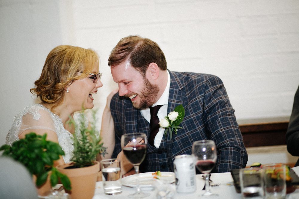 Couple sharing intimate conversation over wine at formal dinner table.