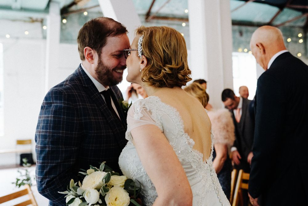 A tender moment between a couple in formal attire at their wedding celebration.